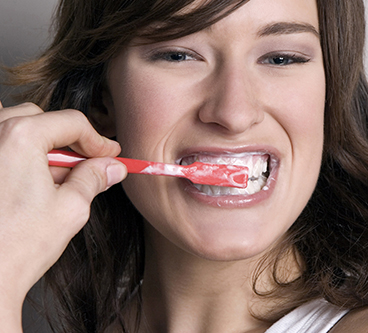 woman brushing her teeth too hard