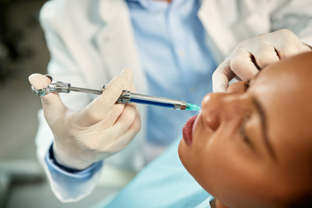 Close-up of black woman receiving anesthetic for tooth extraction